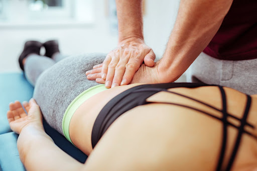 massage therapist massaging woman's lower back